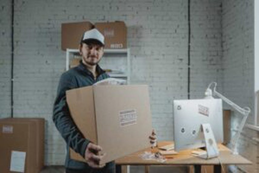 A man lifts a box in a warehouse