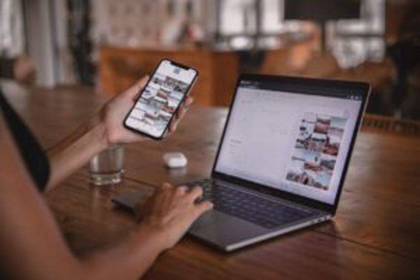 A person looks at the interface of a phone and laptop