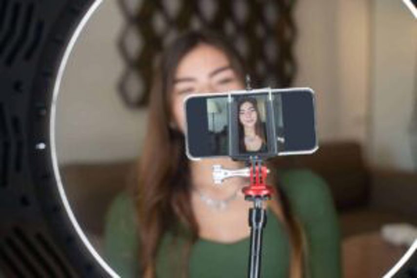 A woman live streams through a smartphone