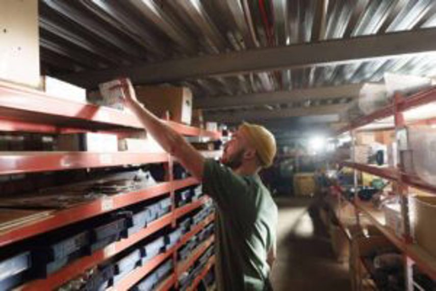 A man picks goods from a shelf in a wholesale warehouse