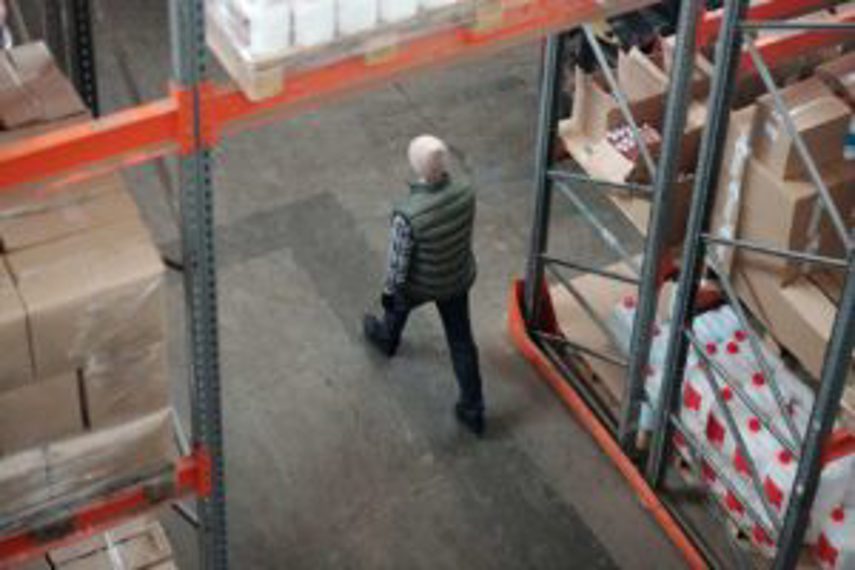 A man walks through a warehouse full of inventory