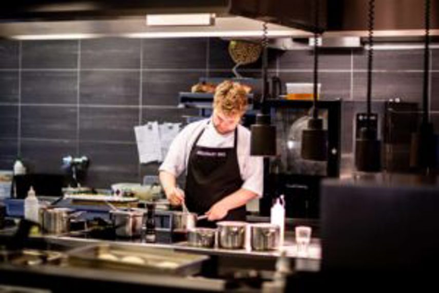 A man prepares food in an industrial kitchen