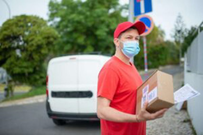 A man wearing a mask delivers packages