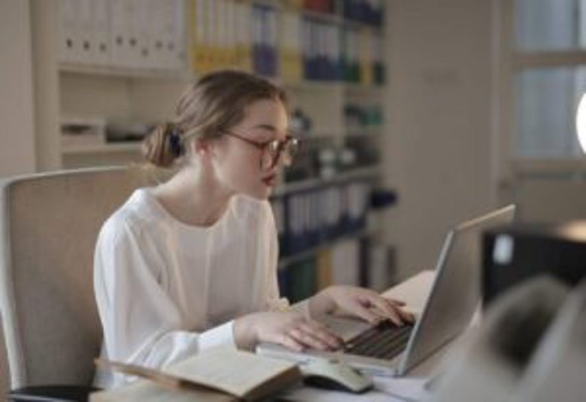 A woman types on her computer in an office