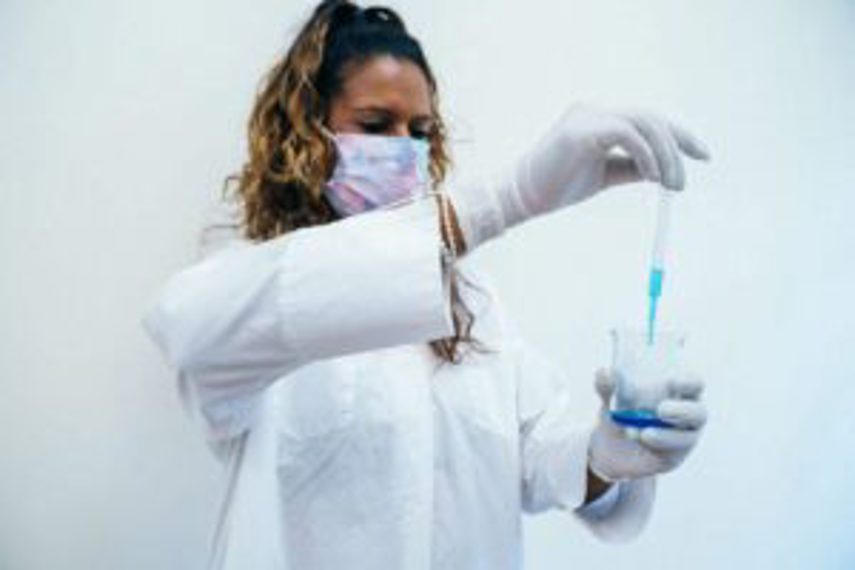 A woman testing a liquid in a lab