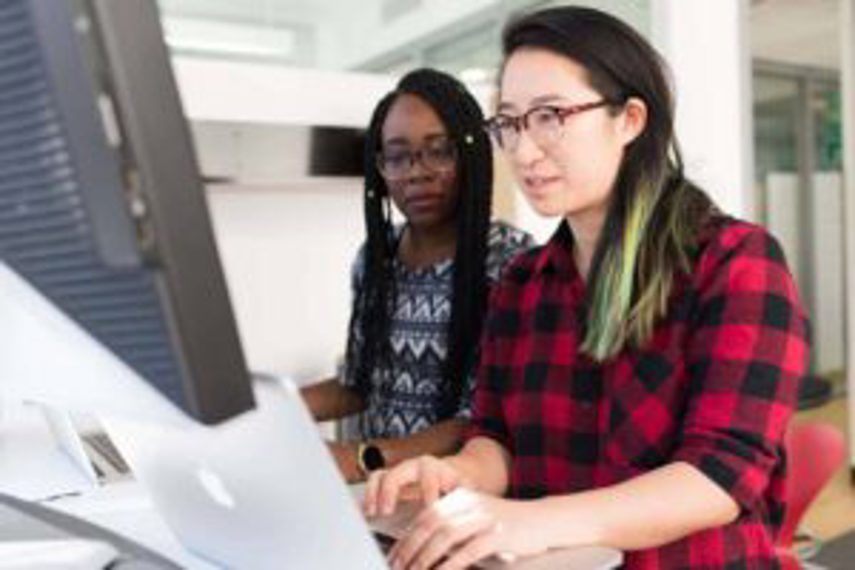 Two people work at a computer