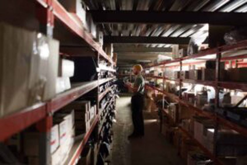 A man looks at stock on warehouse shelves