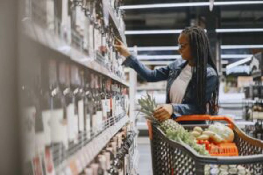 A woman browses products in a supermarket aisle