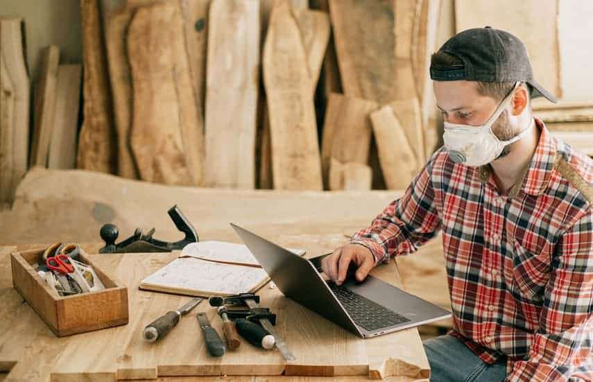 Man using laptop in manufacturing facility to improve processes