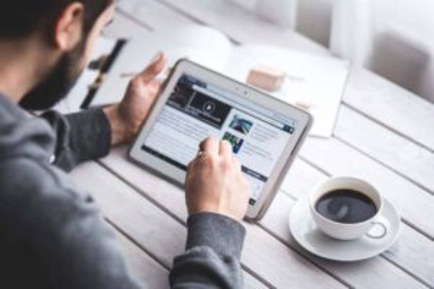 A man working on his tablet with a coffee