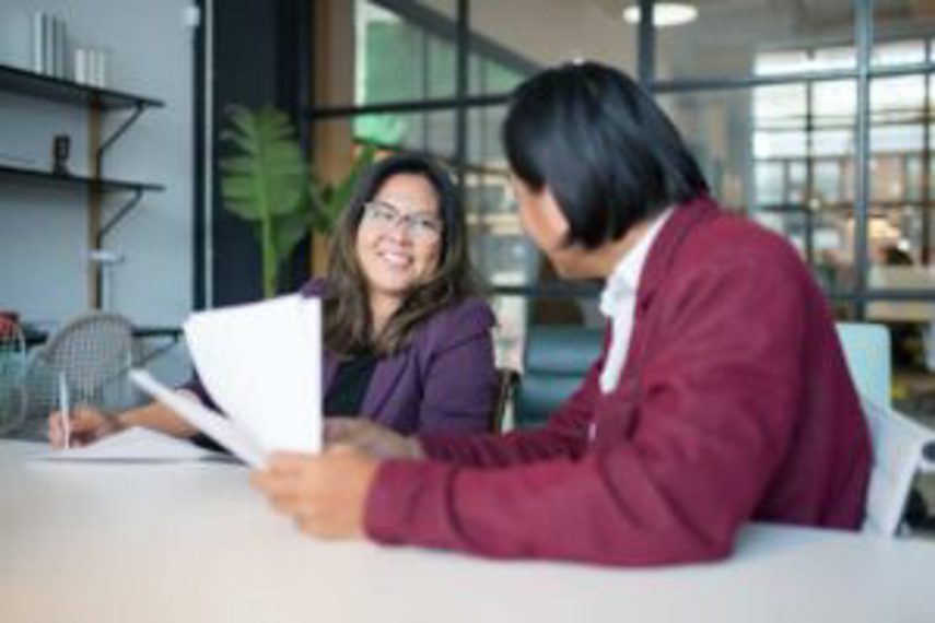 A man and a woman talking in an office at a desk