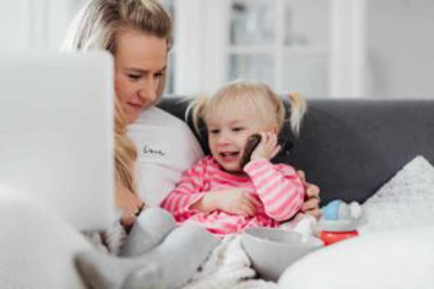 A girl talks on a cellphone while her mother sits next to her