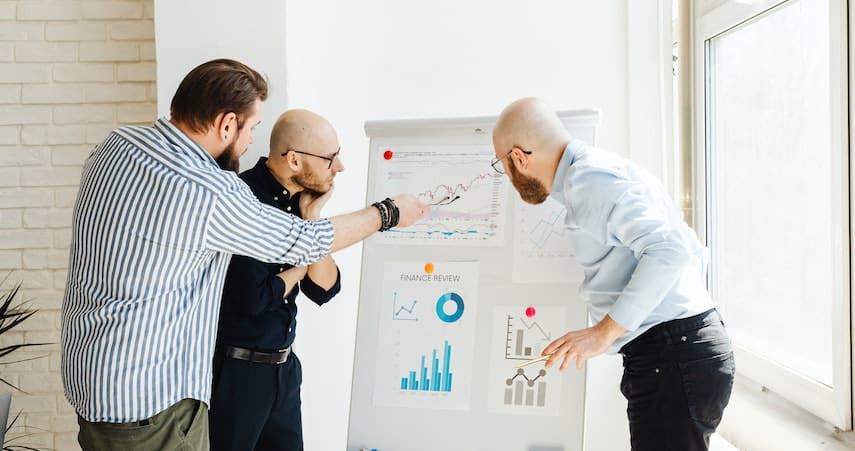 three men look at an inventory control chart