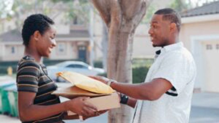 A man hands over post parcels to a woman