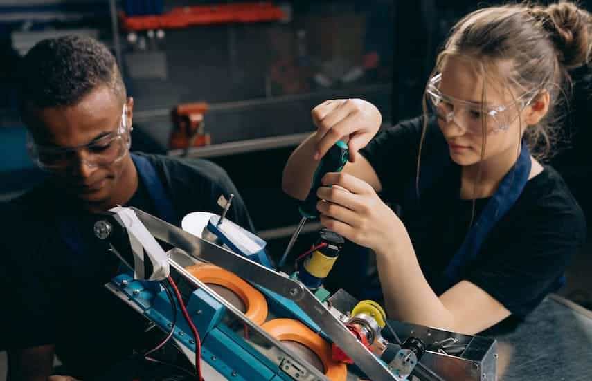 man and woman apply process improvement techniques in manufacturing workshop