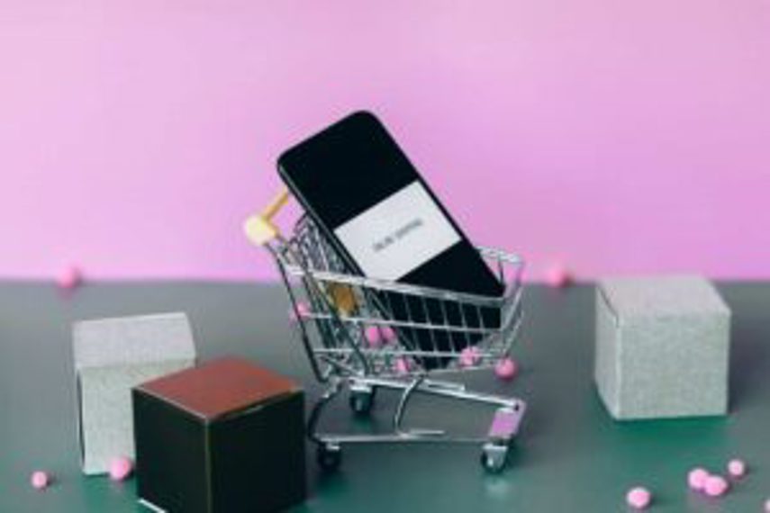 A mini shopping cart with a cellphone in it