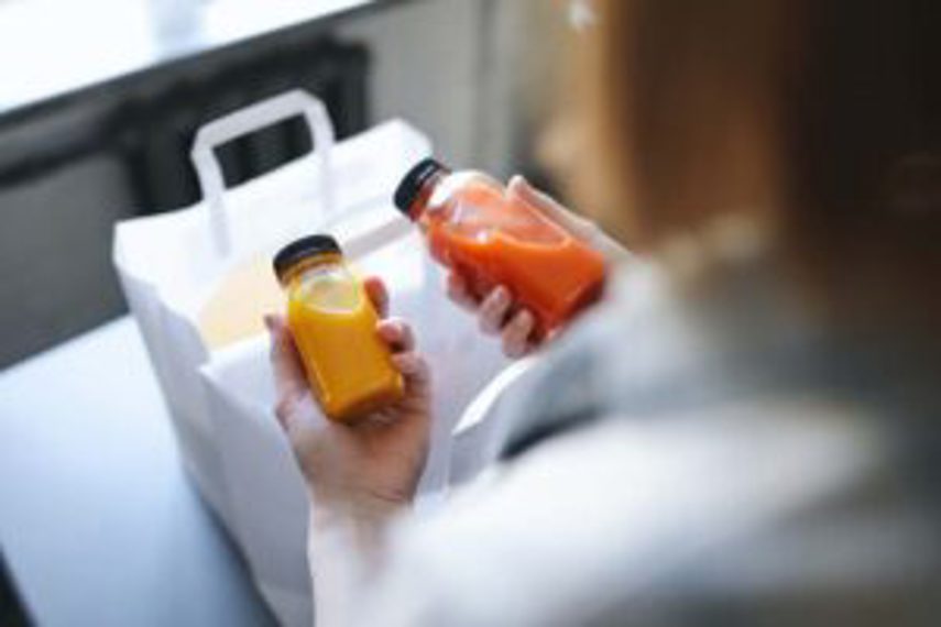 A person takes two bottles of juice from a bag