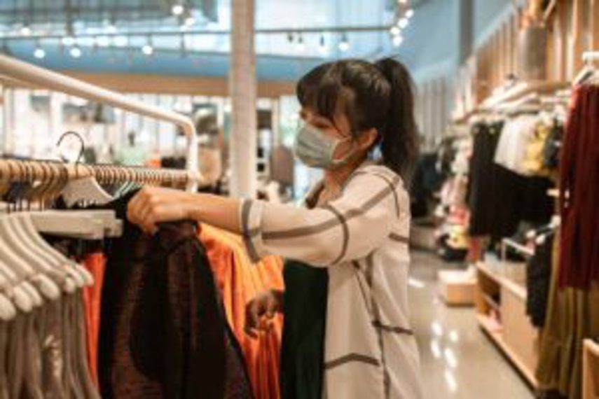 A woman looks at clothing in a store