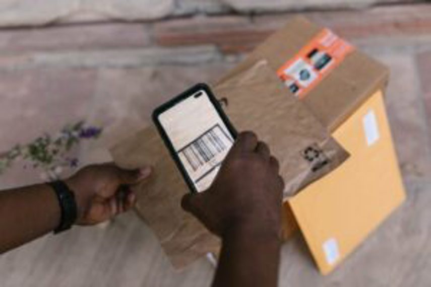 A person scans a barcode on a package