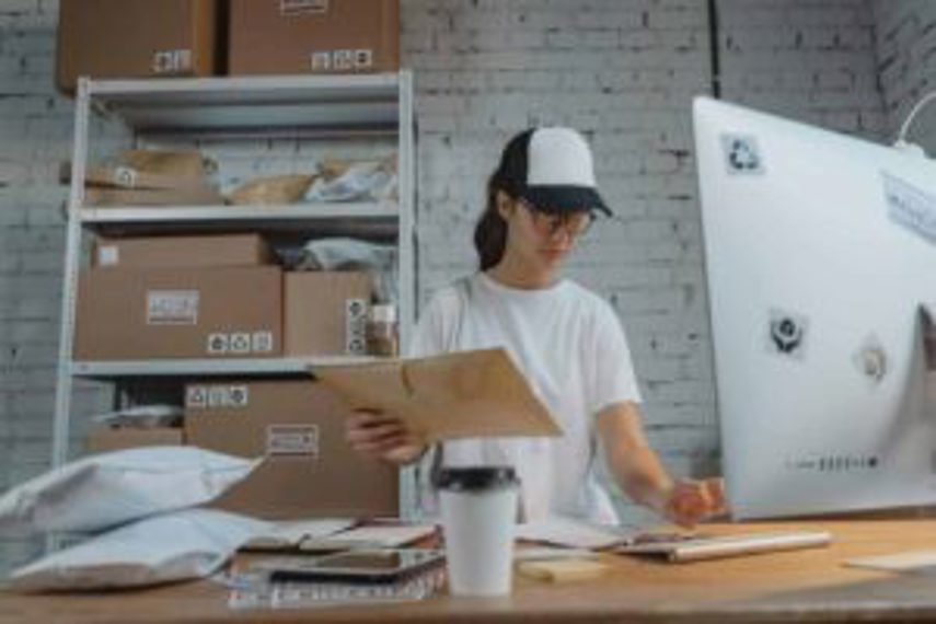 A woman sorts packages using her computer