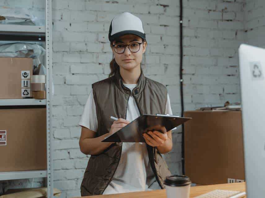 Warehouse order picker holding a clipboard